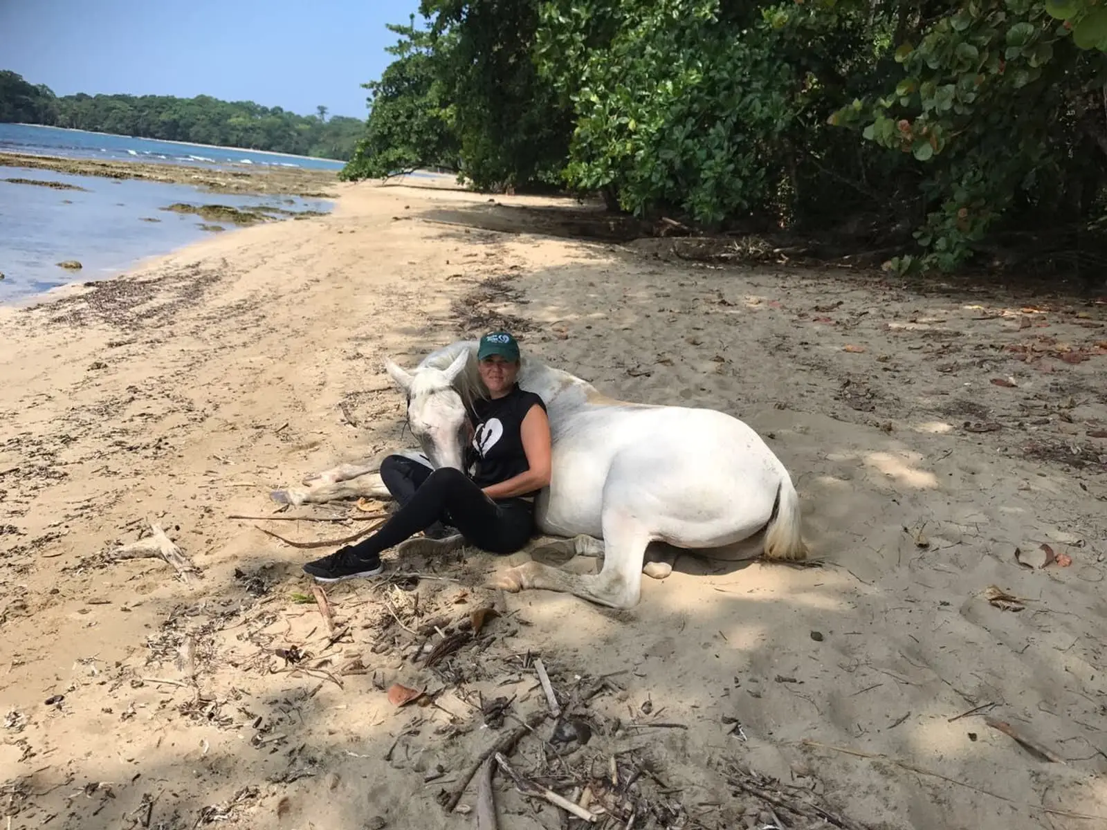 Oriana resting on the beach in Cocles with one of the rescued horses